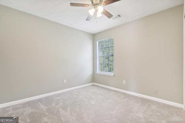 spare room featuring light colored carpet and ceiling fan