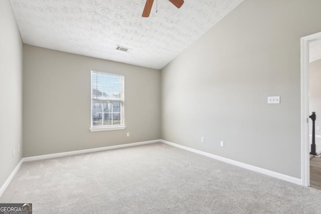 spare room featuring ceiling fan, carpet, and a textured ceiling