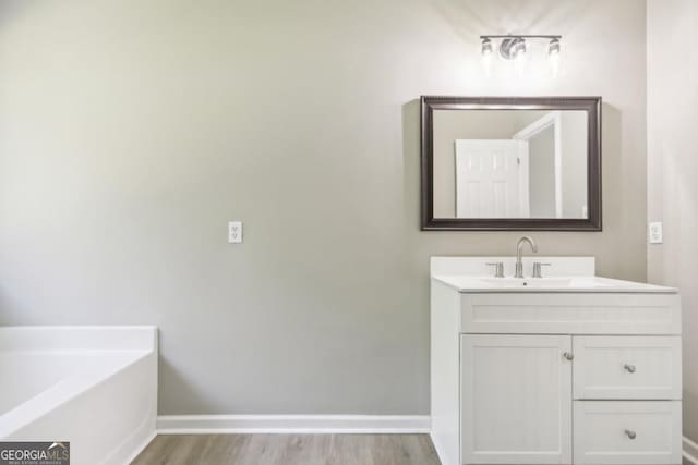 bathroom featuring a bathing tub, vanity, and hardwood / wood-style flooring