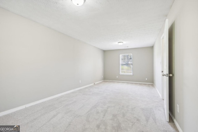 unfurnished room featuring light colored carpet and a textured ceiling