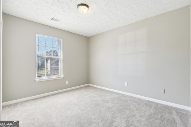 spare room with carpet and a textured ceiling