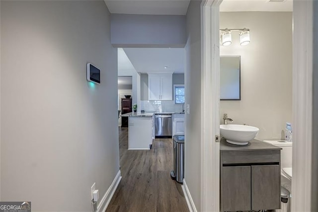 hallway featuring dark wood-type flooring and sink