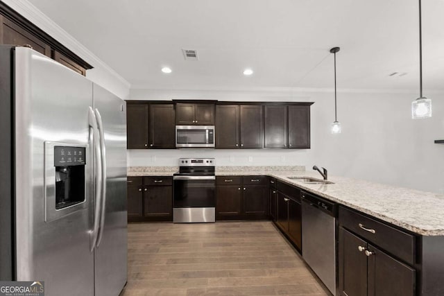 kitchen featuring appliances with stainless steel finishes, crown molding, sink, decorative light fixtures, and hardwood / wood-style flooring