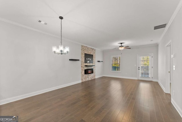 unfurnished living room featuring a fireplace, ceiling fan with notable chandelier, dark wood-type flooring, and ornamental molding