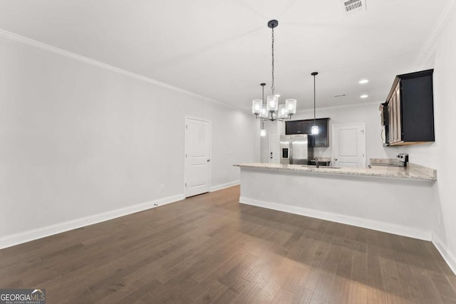 kitchen with dark hardwood / wood-style floors, stainless steel fridge, light stone countertops, ornamental molding, and kitchen peninsula