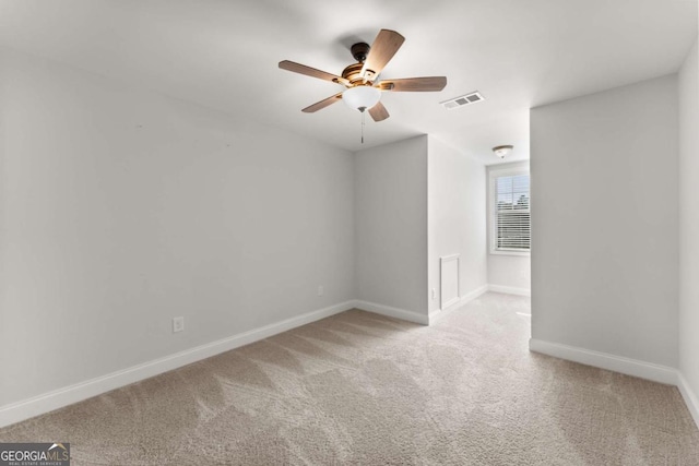 carpeted spare room featuring ceiling fan