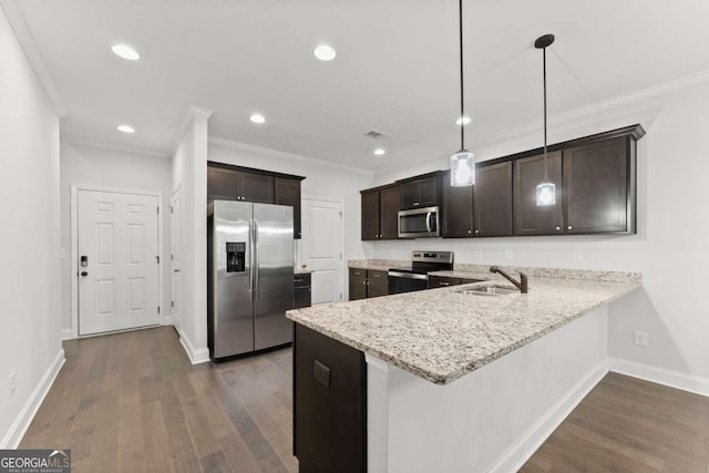 kitchen with ornamental molding, stainless steel appliances, dark wood-type flooring, sink, and hanging light fixtures