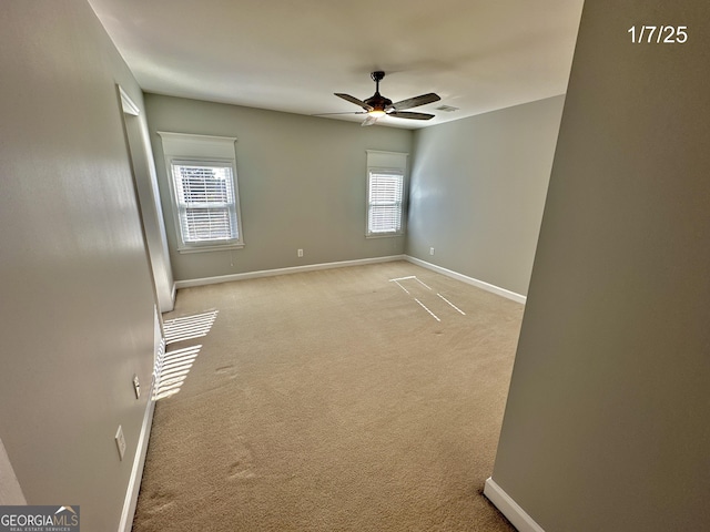 carpeted empty room with a wealth of natural light and ceiling fan