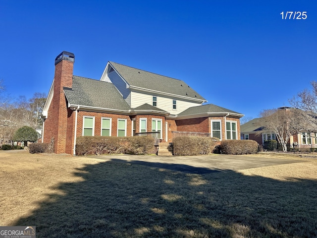 rear view of house featuring a yard