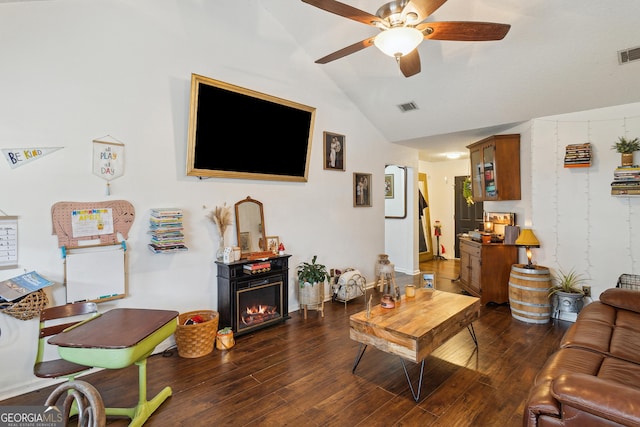 living room featuring ceiling fan, dark hardwood / wood-style flooring, and vaulted ceiling