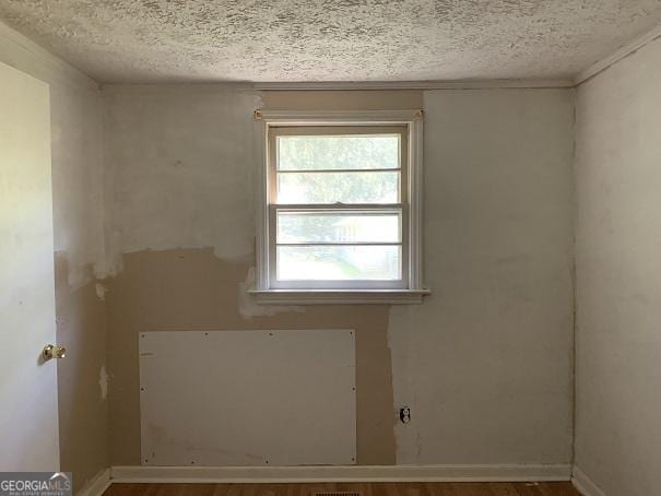 spare room with hardwood / wood-style flooring and a textured ceiling