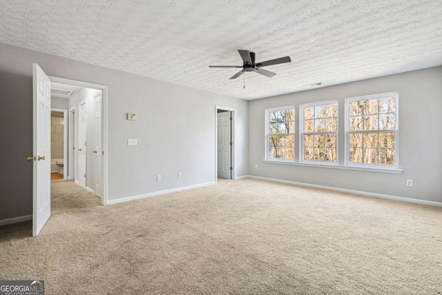 unfurnished bedroom with ceiling fan, light colored carpet, and a textured ceiling