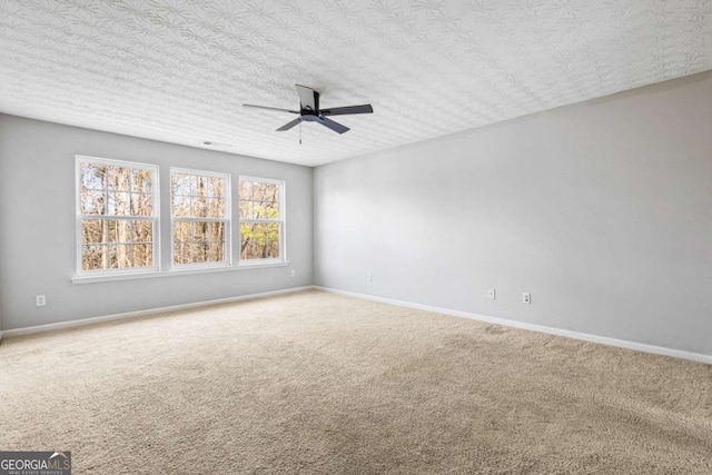 carpeted spare room featuring a textured ceiling and ceiling fan