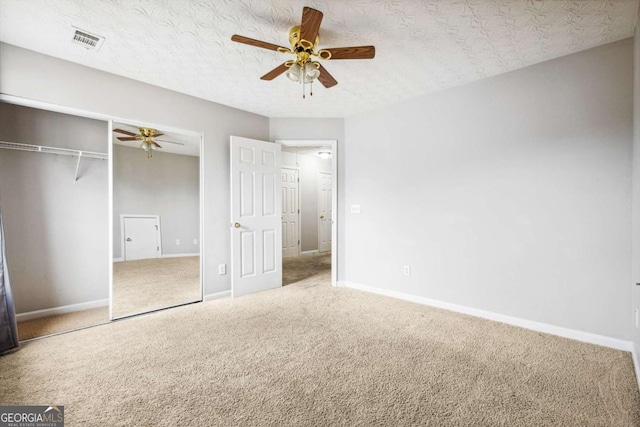 unfurnished bedroom featuring a textured ceiling, a closet, ceiling fan, and carpet floors