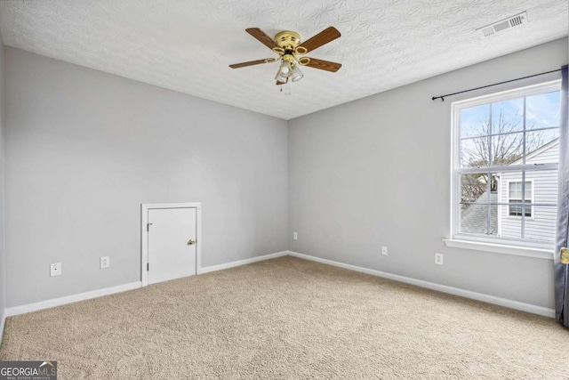 spare room featuring carpet, ceiling fan, and a textured ceiling