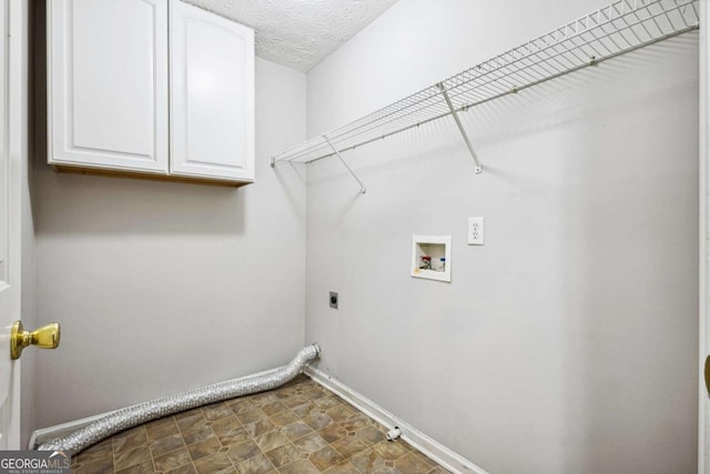 clothes washing area featuring electric dryer hookup, cabinets, gas dryer hookup, washer hookup, and a textured ceiling