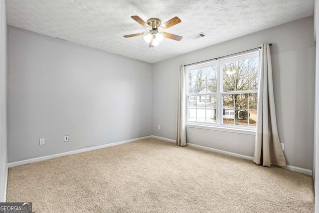 carpeted empty room with ceiling fan and a textured ceiling