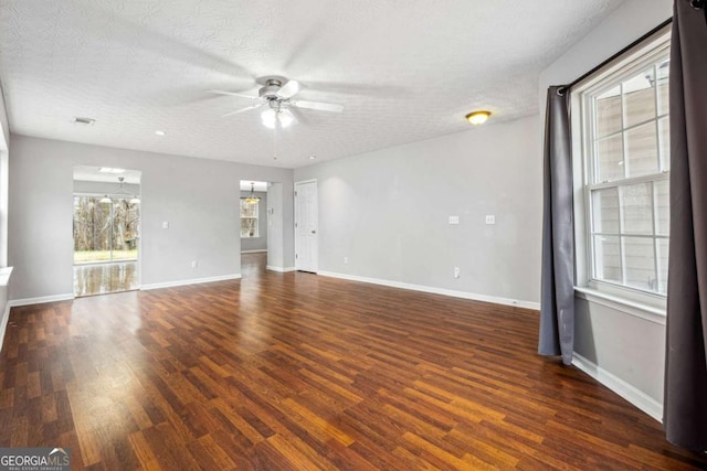 unfurnished living room with ceiling fan, a textured ceiling, wood finished floors, visible vents, and baseboards