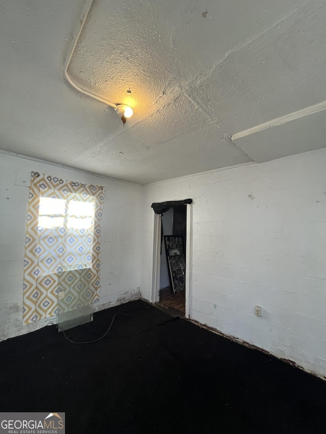 unfurnished room with a textured ceiling