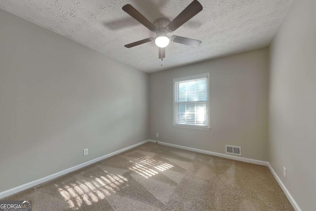 carpeted spare room with ceiling fan and a textured ceiling