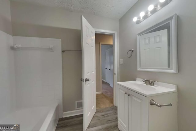 bathroom featuring vanity, a textured ceiling, and hardwood / wood-style flooring