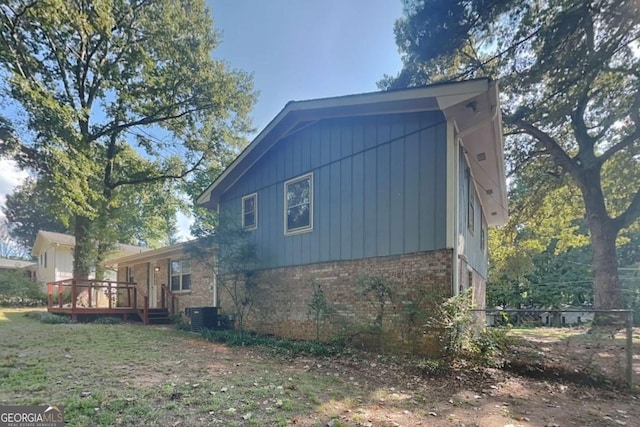 view of side of property with central AC unit and a deck