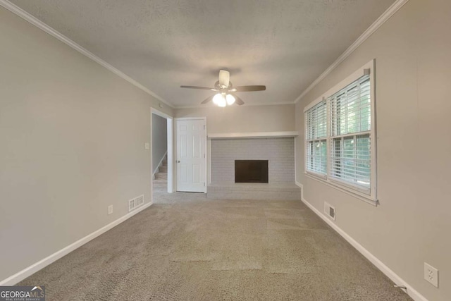 unfurnished living room featuring ceiling fan, crown molding, a textured ceiling, a fireplace, and carpet