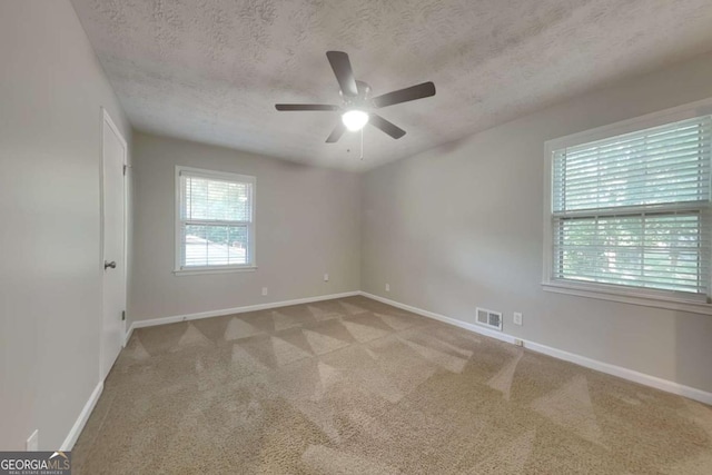 carpeted empty room featuring ceiling fan and a textured ceiling