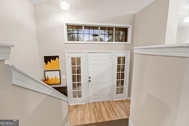 foyer entrance featuring hardwood / wood-style flooring and a towering ceiling