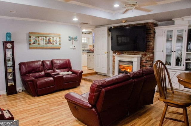 living room with crown molding, ceiling fan, and light wood-type flooring