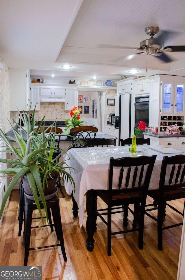 dining area with light hardwood / wood-style floors and ceiling fan