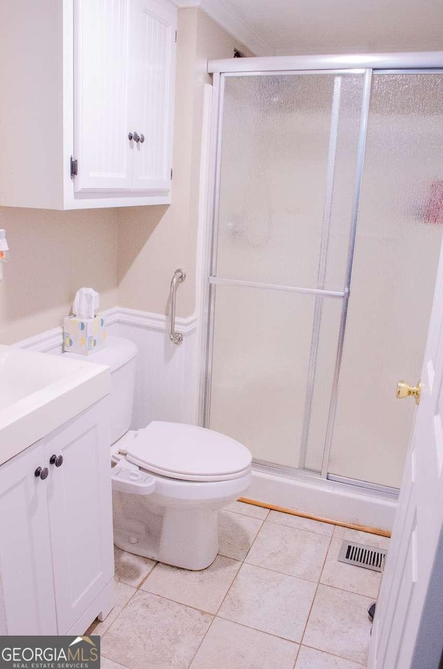 bathroom featuring tile patterned floors, vanity, an enclosed shower, and toilet