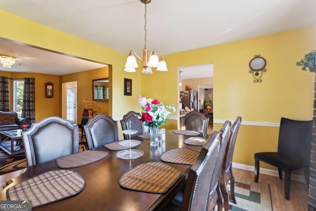 dining room featuring wood-type flooring and a notable chandelier