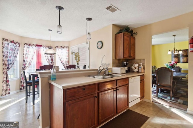 kitchen with a notable chandelier, dishwasher, sink, and hanging light fixtures