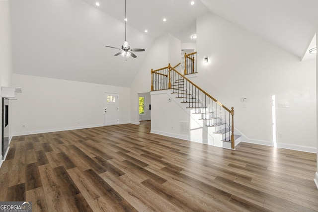 unfurnished living room featuring high vaulted ceiling, ceiling fan, and dark wood-type flooring