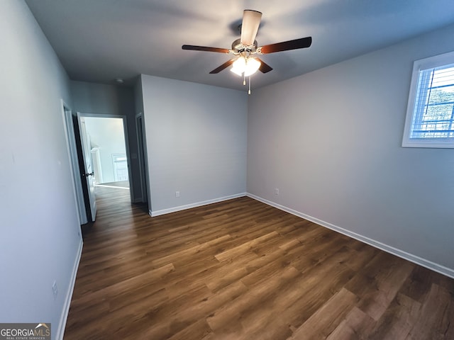 empty room featuring dark hardwood / wood-style flooring and ceiling fan