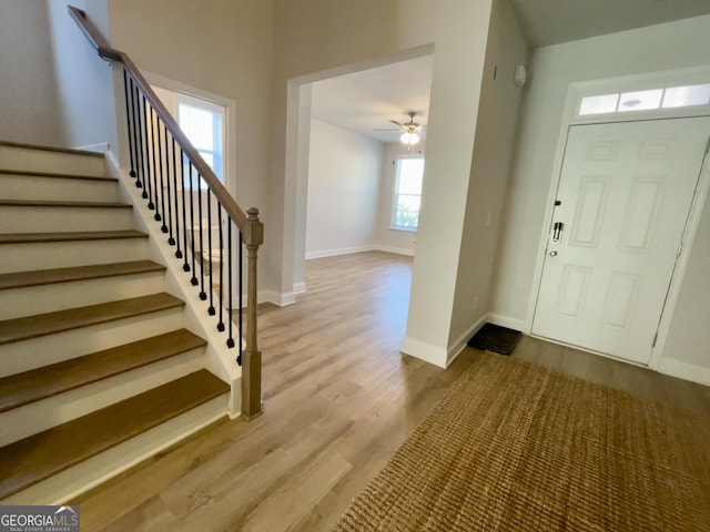 foyer entrance with ceiling fan and light wood-type flooring