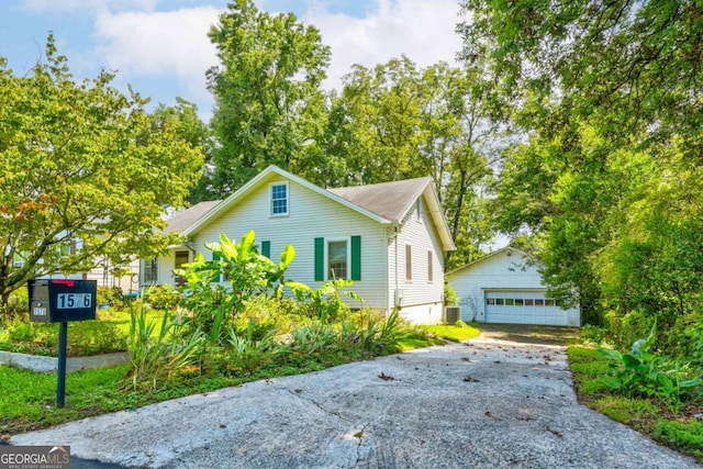 view of front of home featuring a garage, an outdoor structure, and central AC