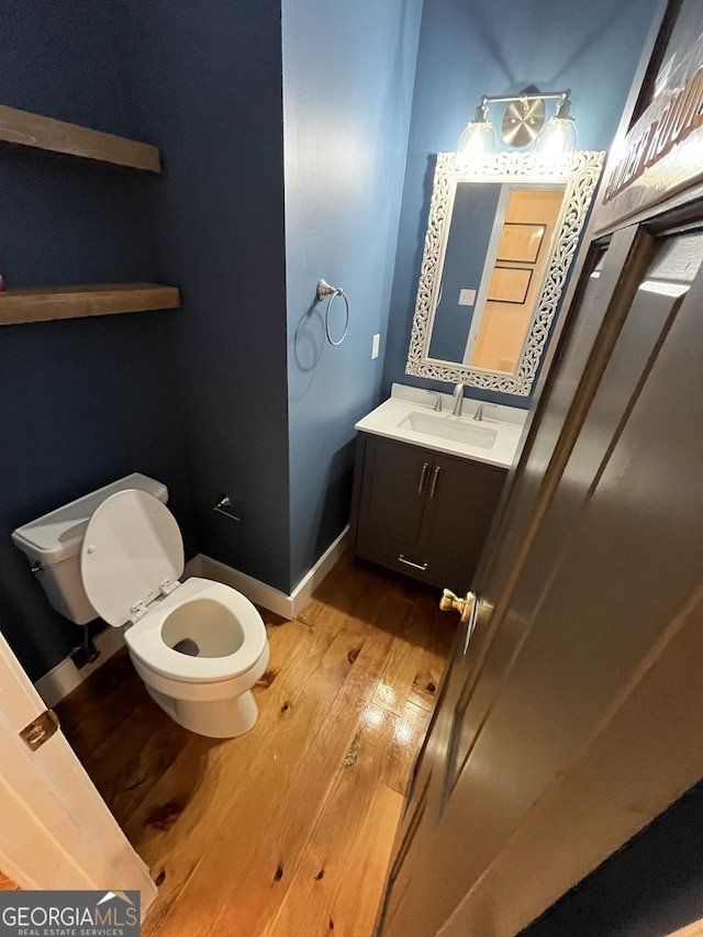 bathroom featuring hardwood / wood-style floors, vanity, and toilet