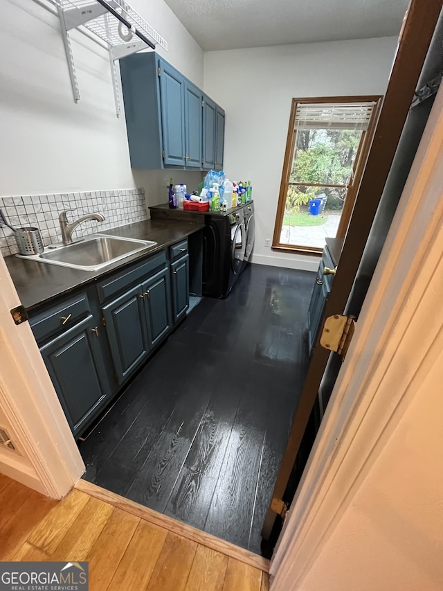 laundry area with washer and dryer, dark hardwood / wood-style flooring, cabinets, and sink