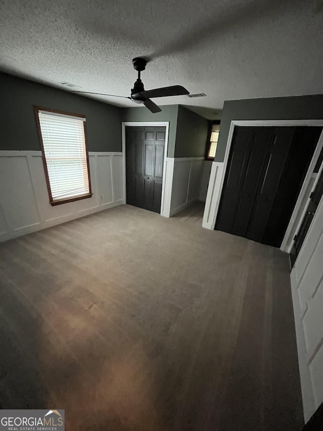 unfurnished bedroom with ceiling fan and a textured ceiling