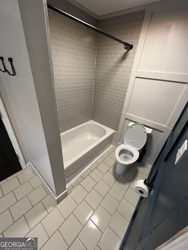 bathroom featuring tile patterned floors, tiled shower / bath combo, and toilet