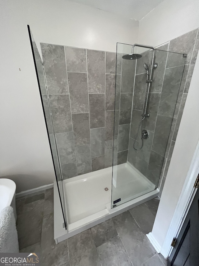 bathroom with tile patterned flooring and tiled shower