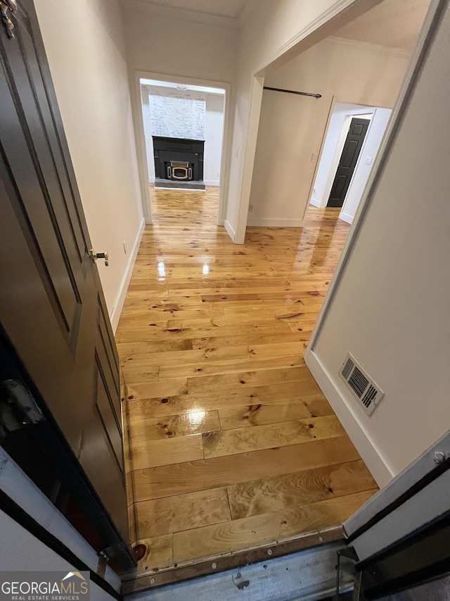 hall featuring light hardwood / wood-style flooring and ornamental molding