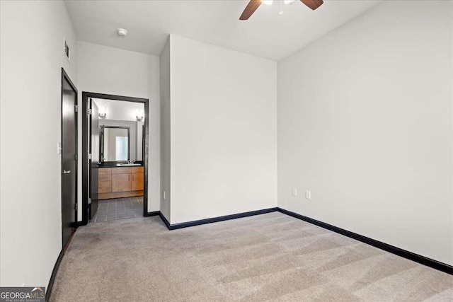 unfurnished room featuring carpet flooring, ceiling fan, and sink