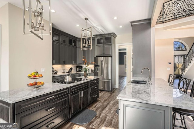 kitchen with a large island, sink, stainless steel appliances, and a breakfast bar