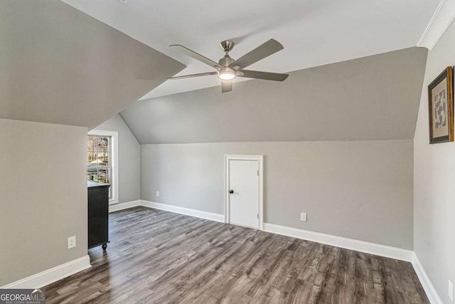 additional living space with ceiling fan, dark wood-type flooring, and vaulted ceiling