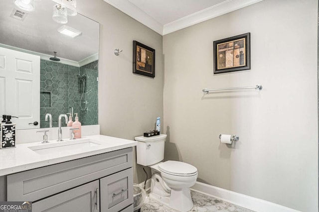 bathroom featuring a tile shower, vanity, toilet, and ornamental molding