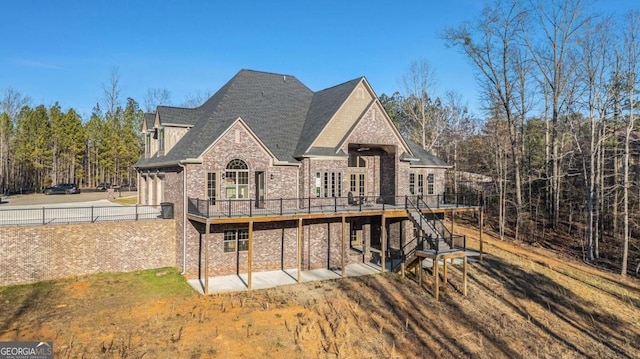 back of property featuring a lawn and a wooden deck