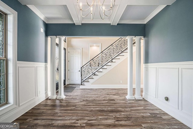 foyer entrance with beam ceiling, ornate columns, a notable chandelier, wood-type flooring, and ornamental molding